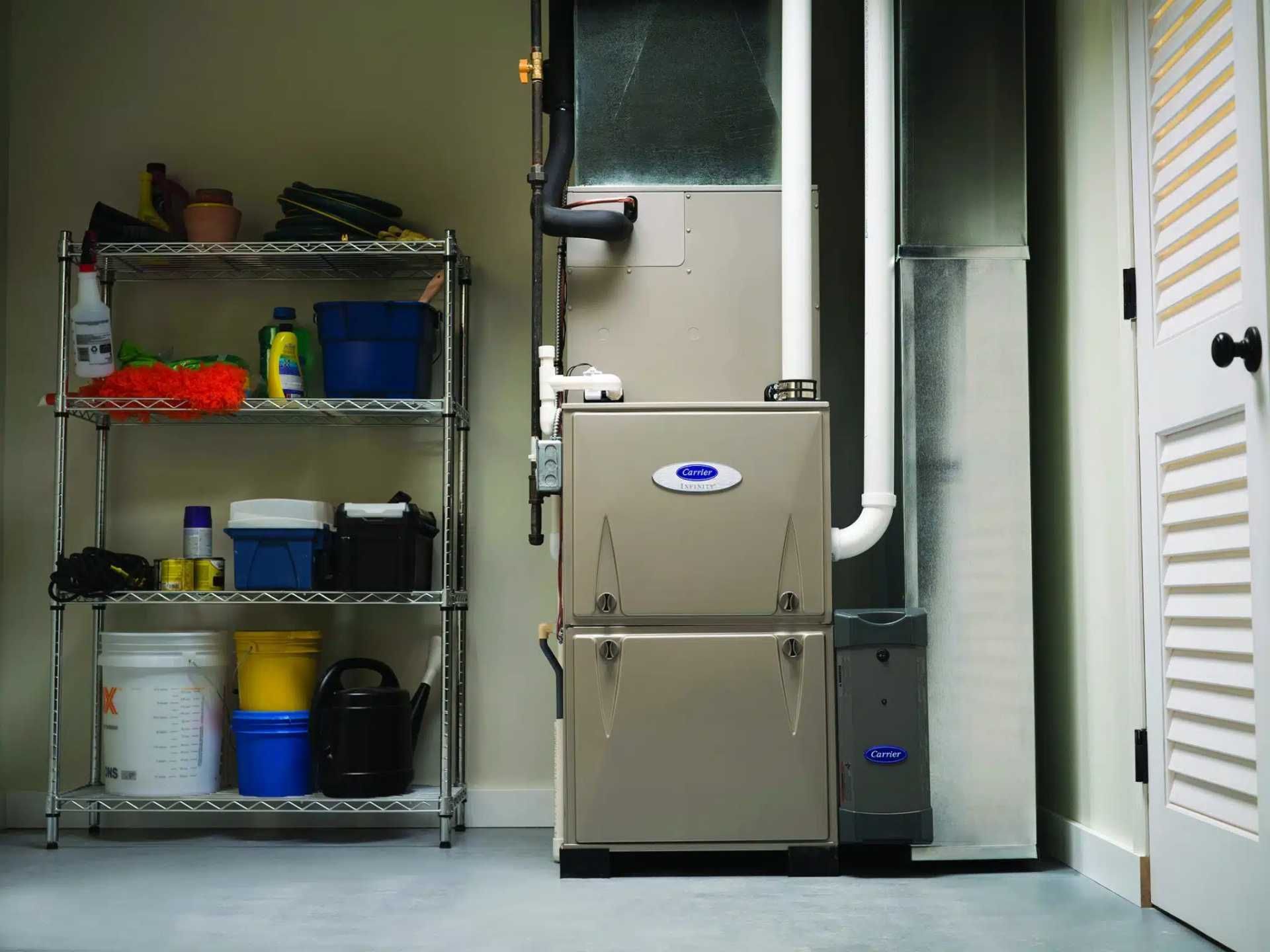 Basement utility room with shelving, bins, and a large metal furnace or HVAC unit.
