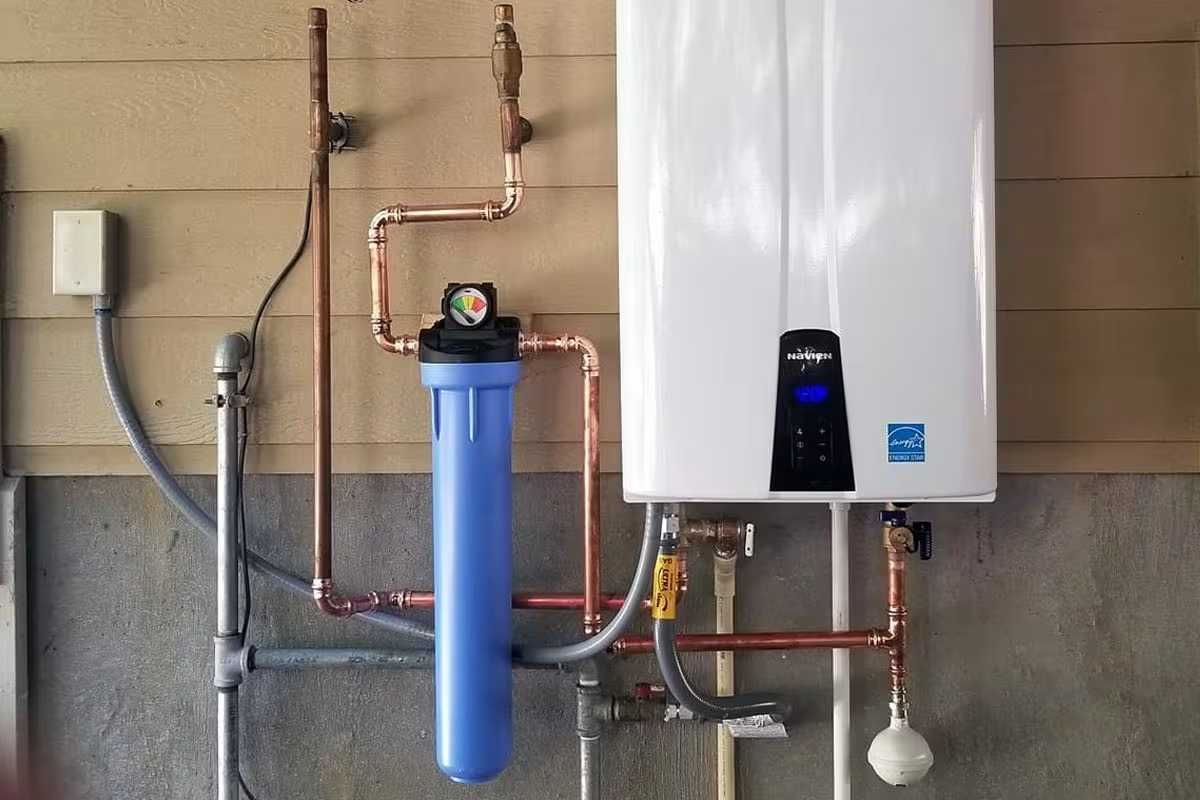 Wall-mounted water heater and blue filtration tank with exposed copper pipes in a utility room