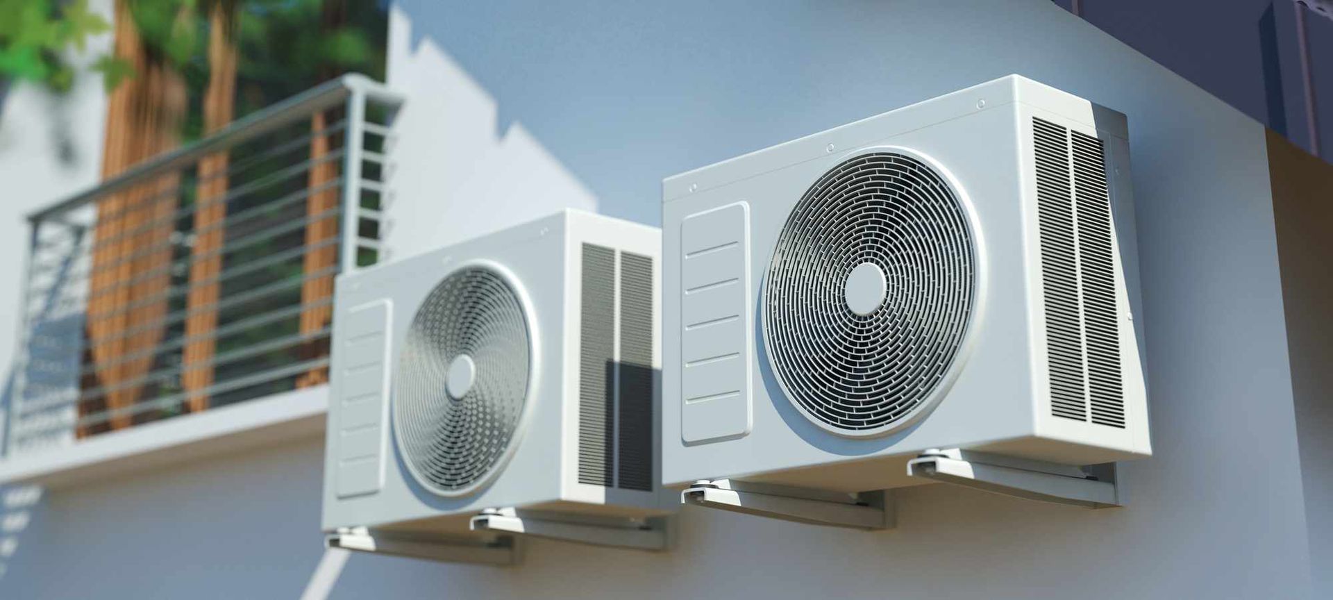 Two outdoor air conditioner units mounted on a building exterior under a balcony.