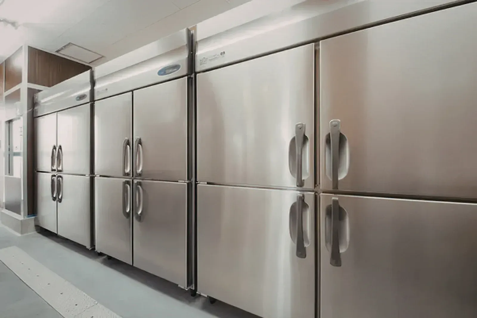 Three white wall-mounted boilers with pipes and valves in a utility room