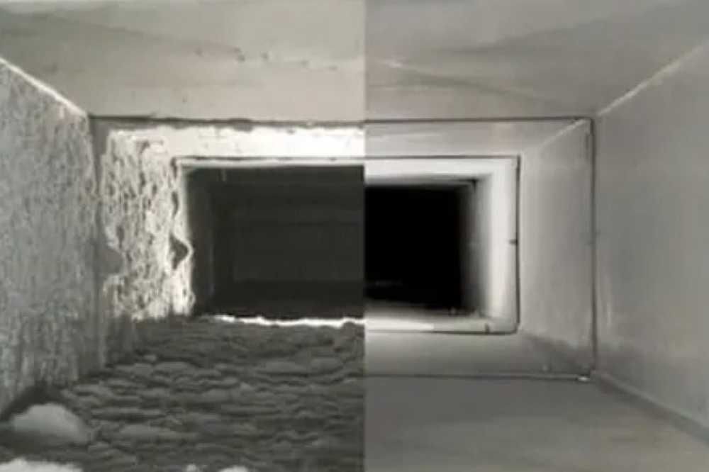 Split view of a ventilation duct interior, half caked with grime and half clean, leading into darkness