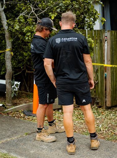 A Person Is Cleaning a Wall with A Spray Bottle — Asbestos Risk Removal In Gladstone, QLD