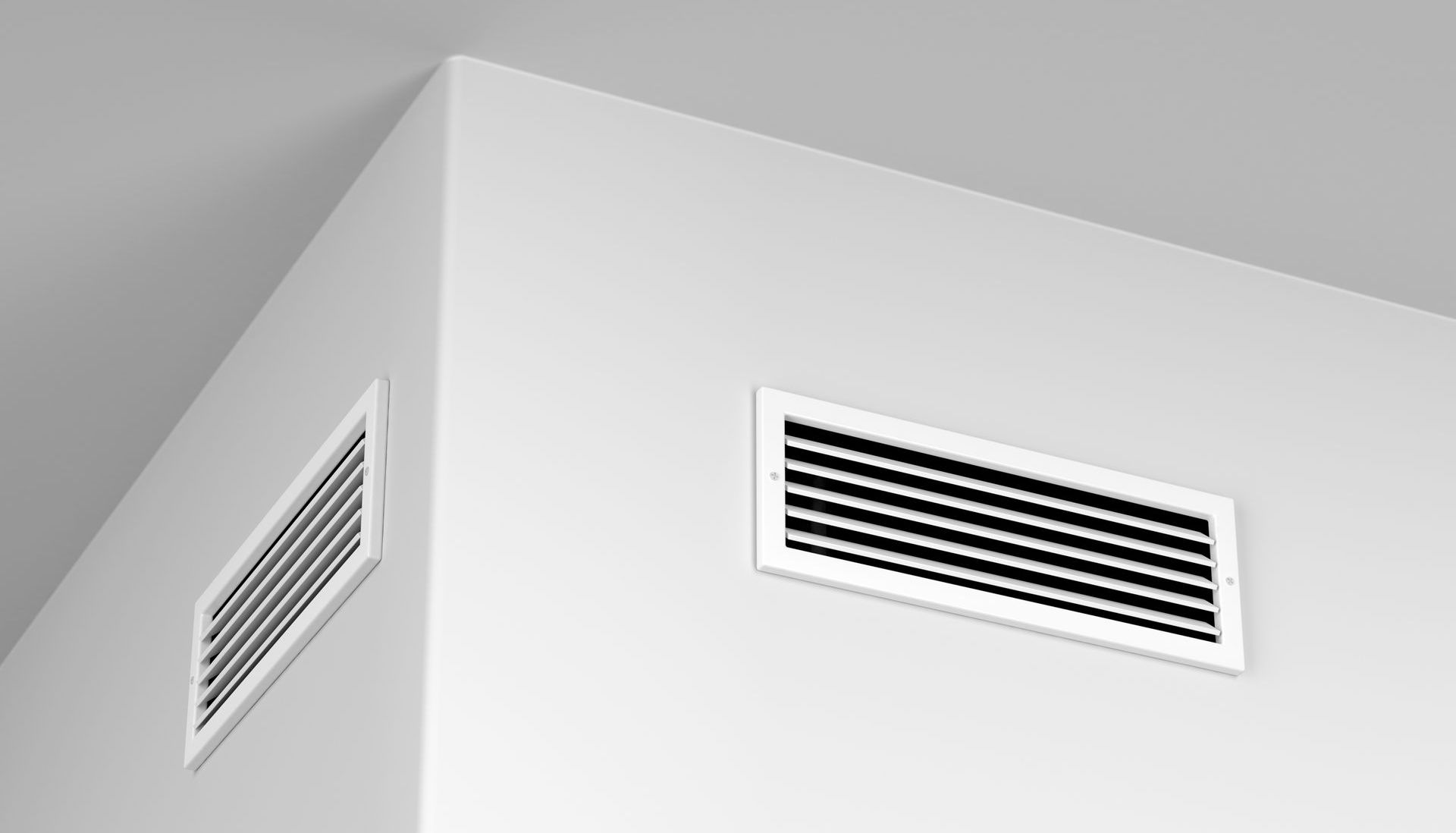 White walls with two rectangular air vents, one in the corner.
