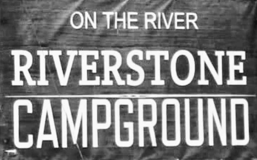 A black and white sign that says on the river riverstone campground