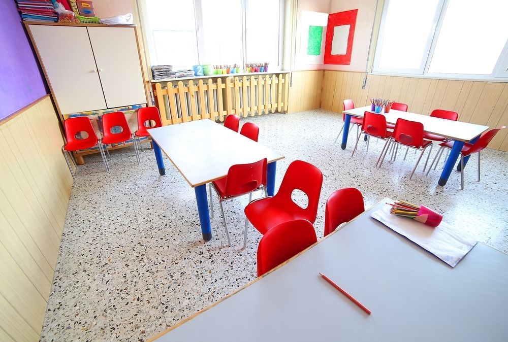 A Brightly Lit Classroom Features White Tables With Red Chairs — Cyclone City Cleaners In Winnellie, NT