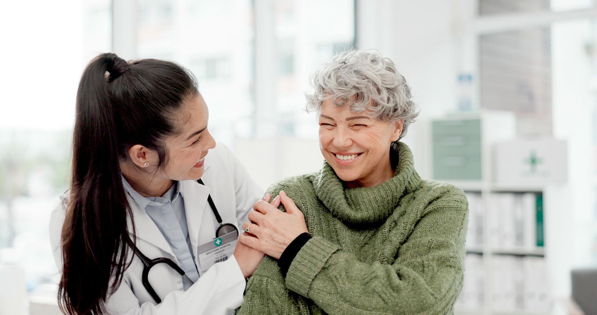 A doctor is talking to an elderly woman in a hospital.