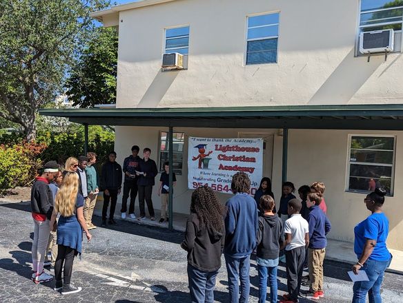 A group of children are standing in front of a building.