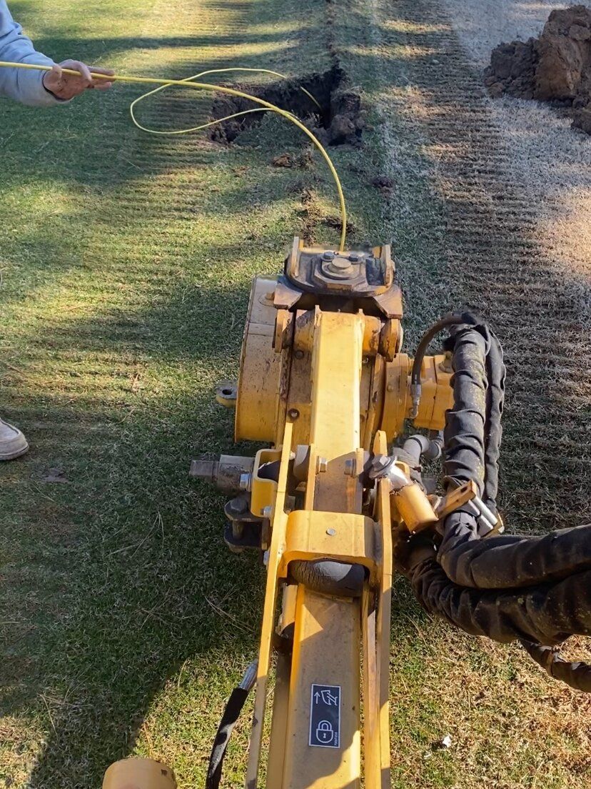 Yellow lawn mower on grass with a long black hose attached, outdoors in a yard