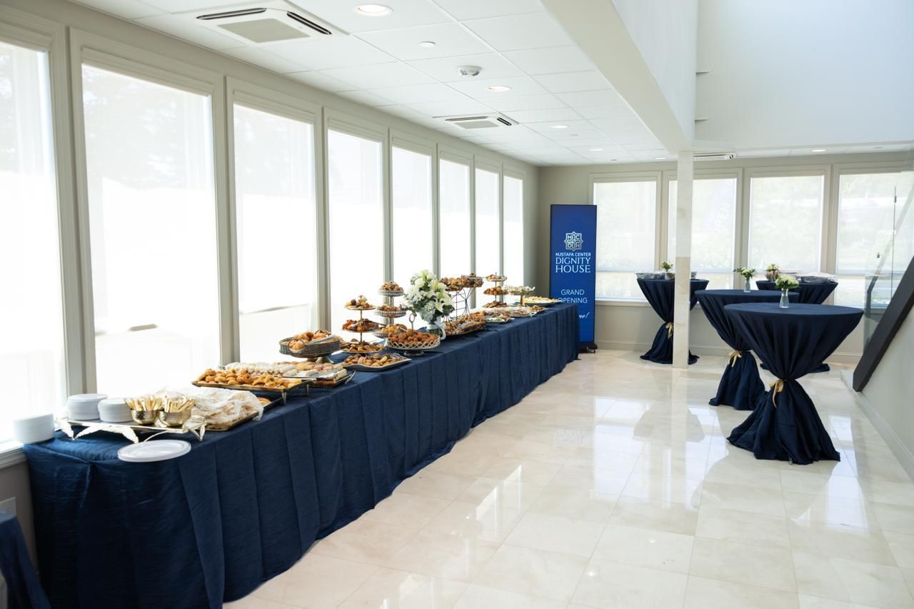 Buffet table with trays of food and covered drinks in a bright conference room
