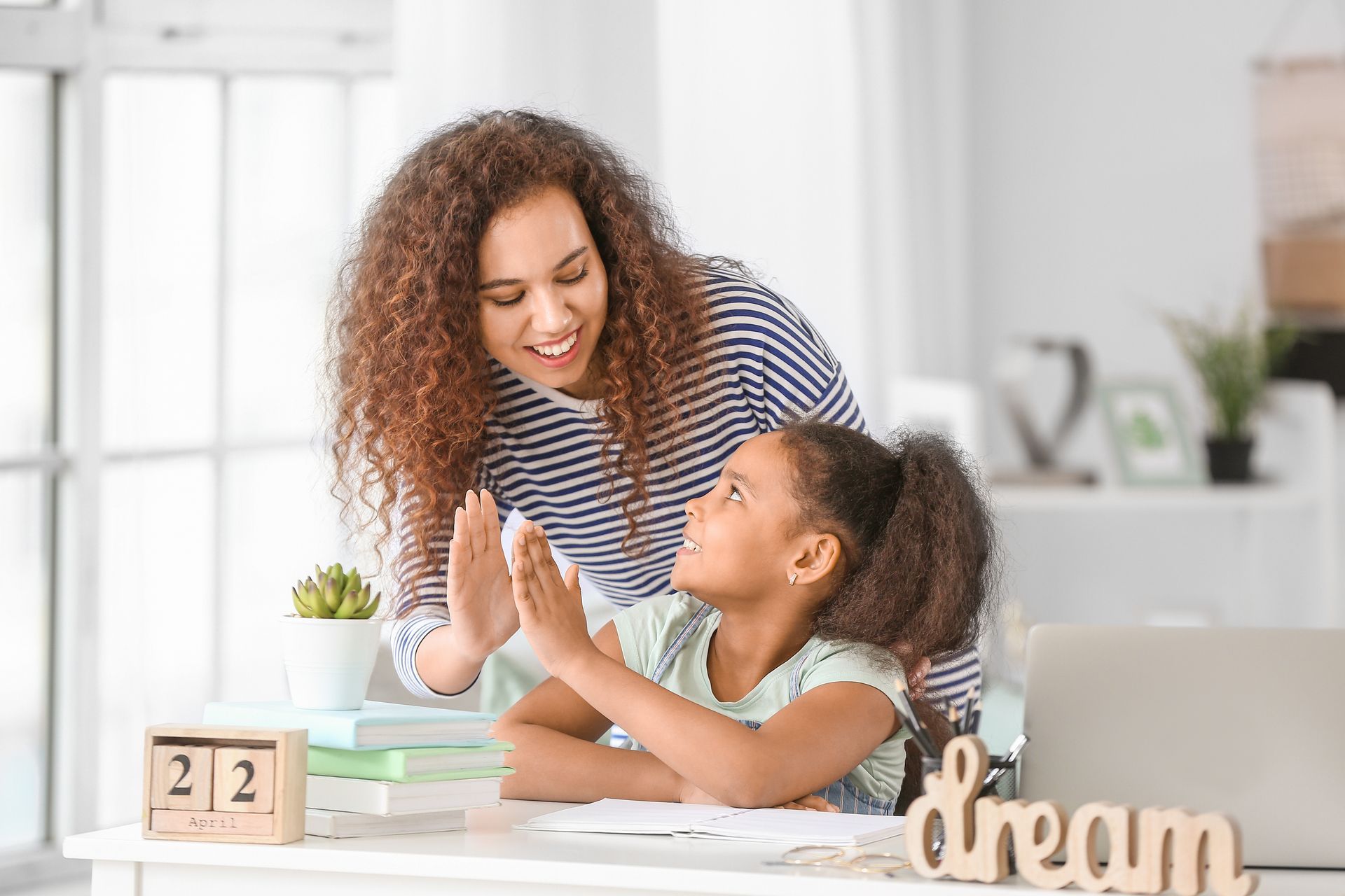 A boy and a girl sitting at a table playing with wooden blocks