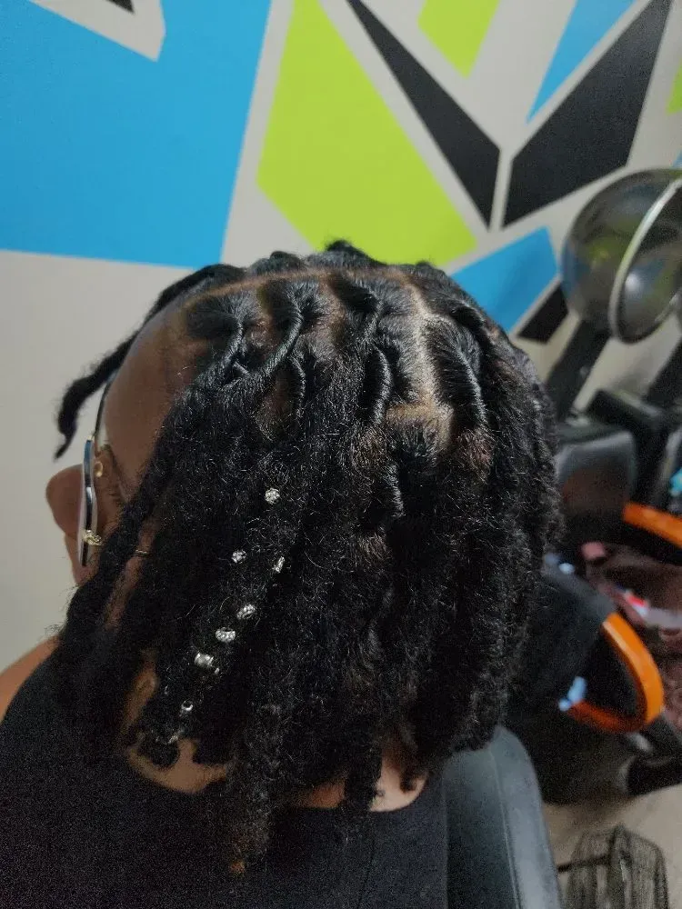 A person with dreadlocks and beads in their hair