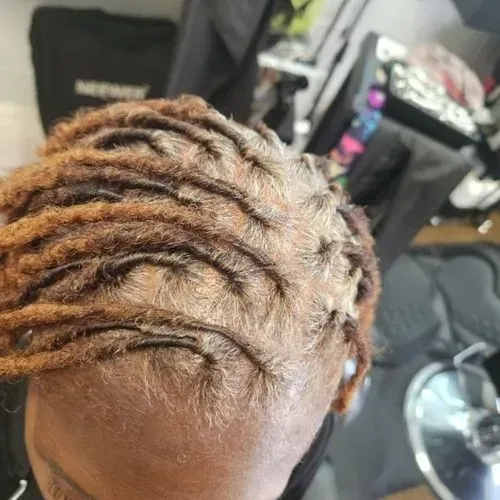 A close up of a woman 's head with dreadlocks in a salon.