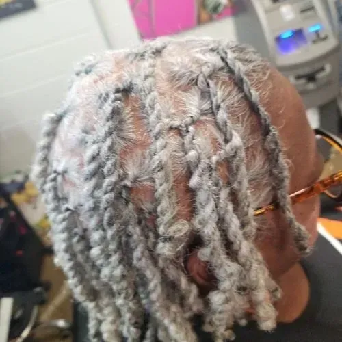 A close up of a person 's head with dreadlocks and glasses.