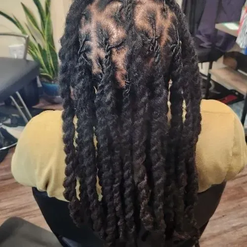 A woman with long dreadlocks is sitting in a chair.