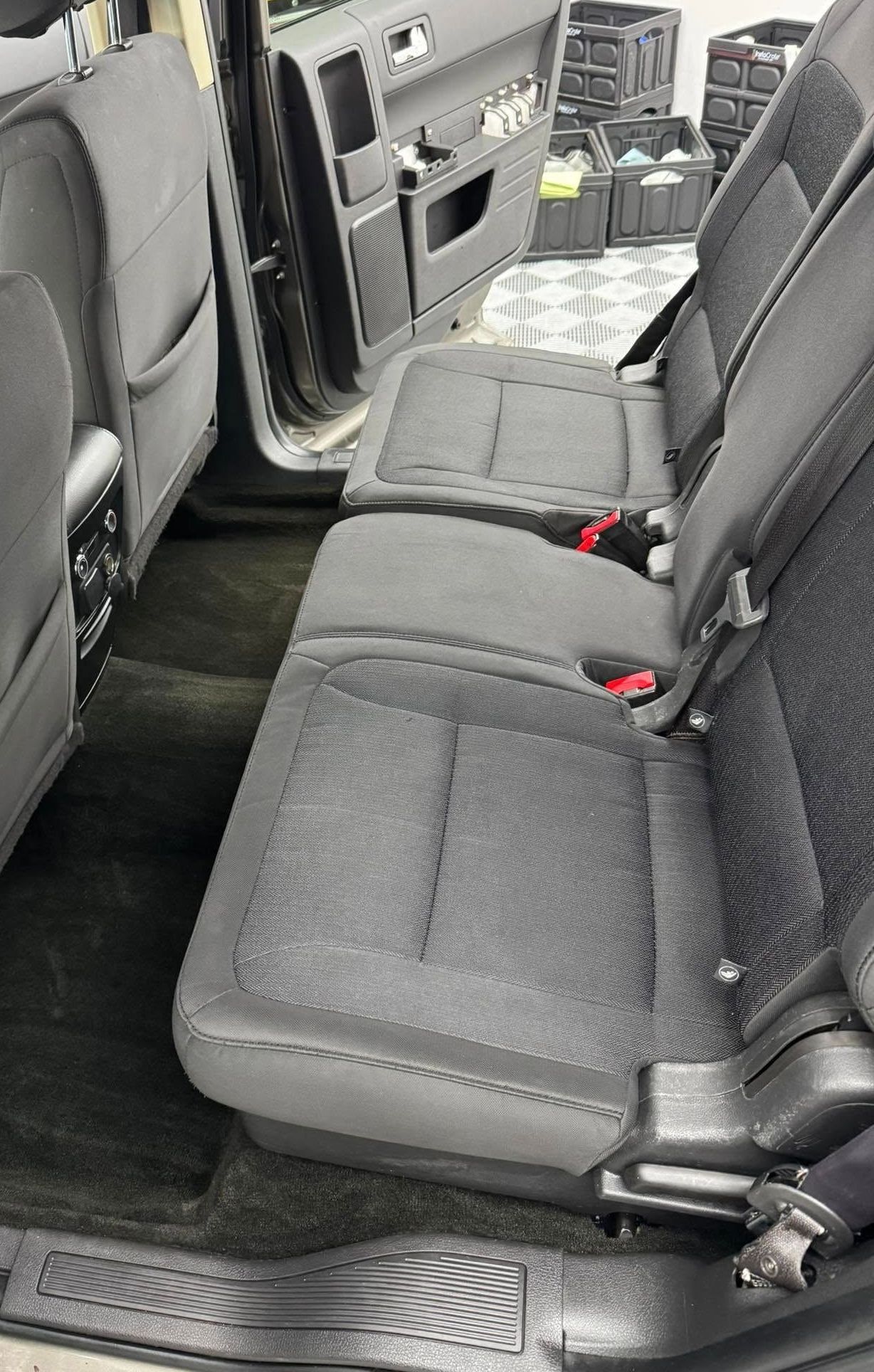 The back seat of a car with the door open.