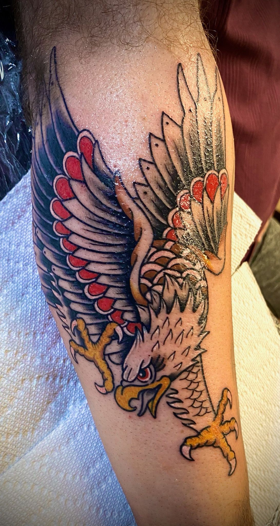 A man has a tattoo of an eagle on his leg.