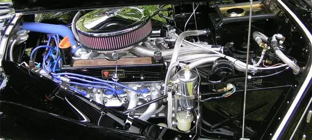 a close up of a black car engine with a chrome air filter .