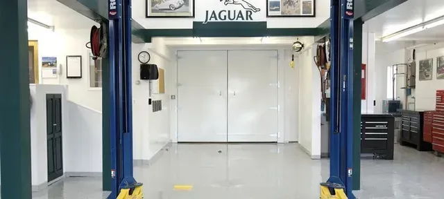 there is a jaguar logo on the wall of the garage .