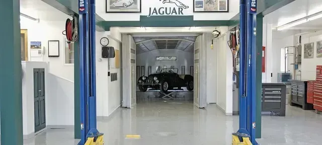 a jaguar is sitting on a lift in a garage .