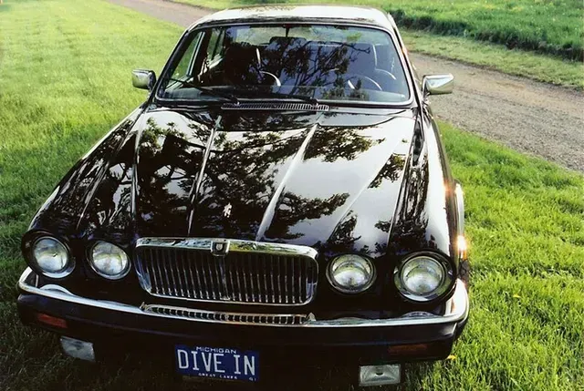 a black car with a michigan license plate that says dive in