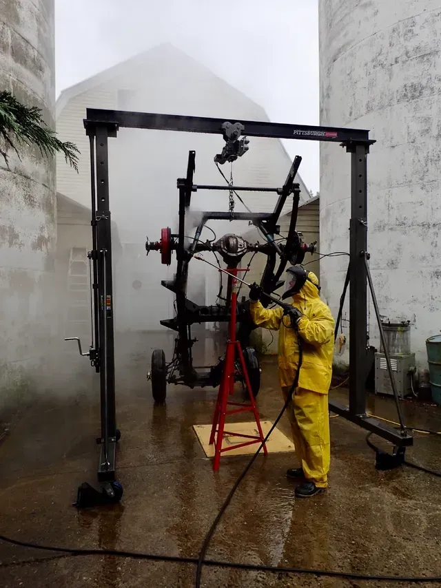 a man in a yellow raincoat is working on a machine that says pittsburg on it