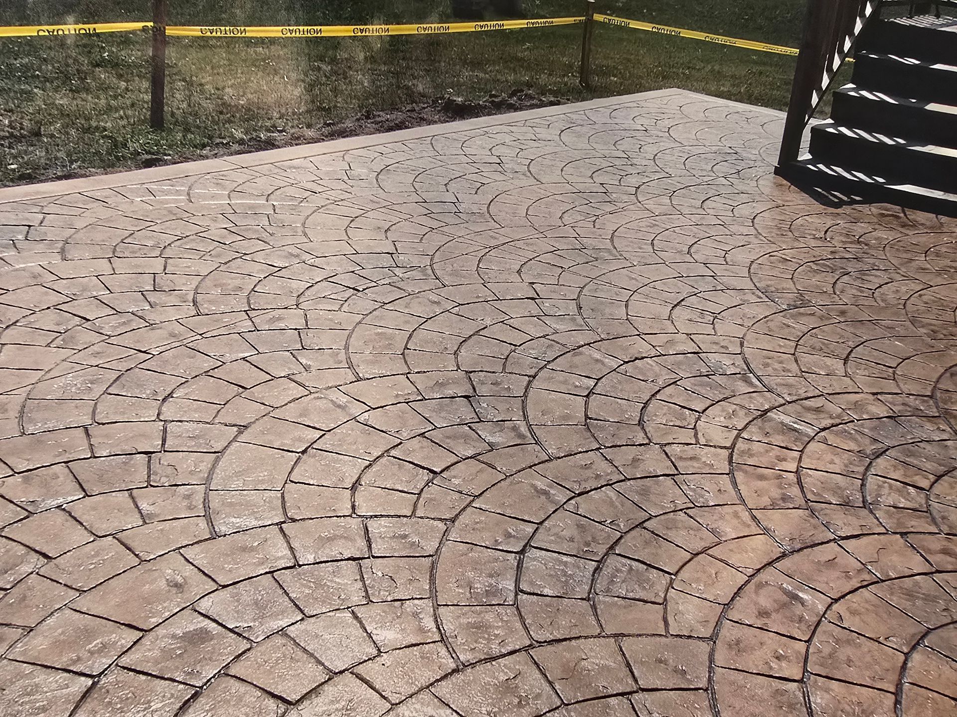 A person is using a high pressure washer to clean a brick walkway.