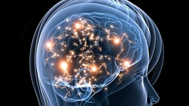 Radiographie d'une tête montrant un cerveau avec une activité électrique brillante ; fond sombre.