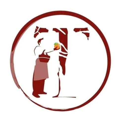 Chef che tiene in mano della frutta, all'interno di un cerchio rosso con la lettera