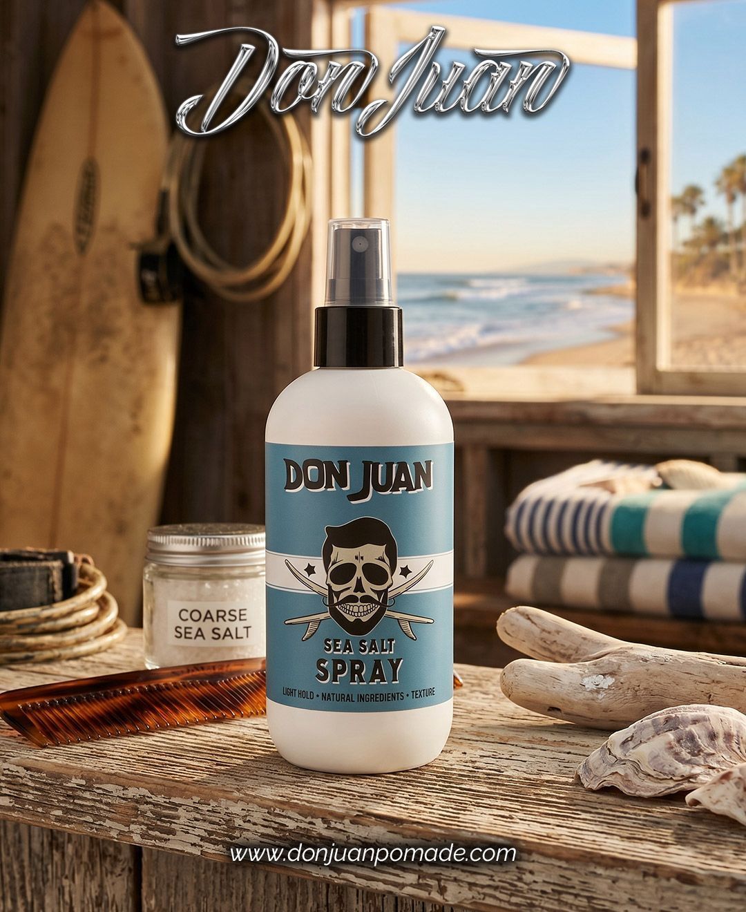 Botella de spray Don Juan azul en una exhibición con temática playera con tabla de surf, toallas y vista al océano.