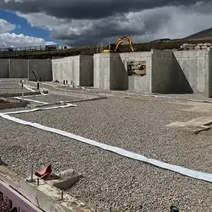 Passive radon system roughed in before the slab pour: clean gravel base, sealed perimeter expansion joint, and vent pipe stub-ups set in the foundation of a new Utah home