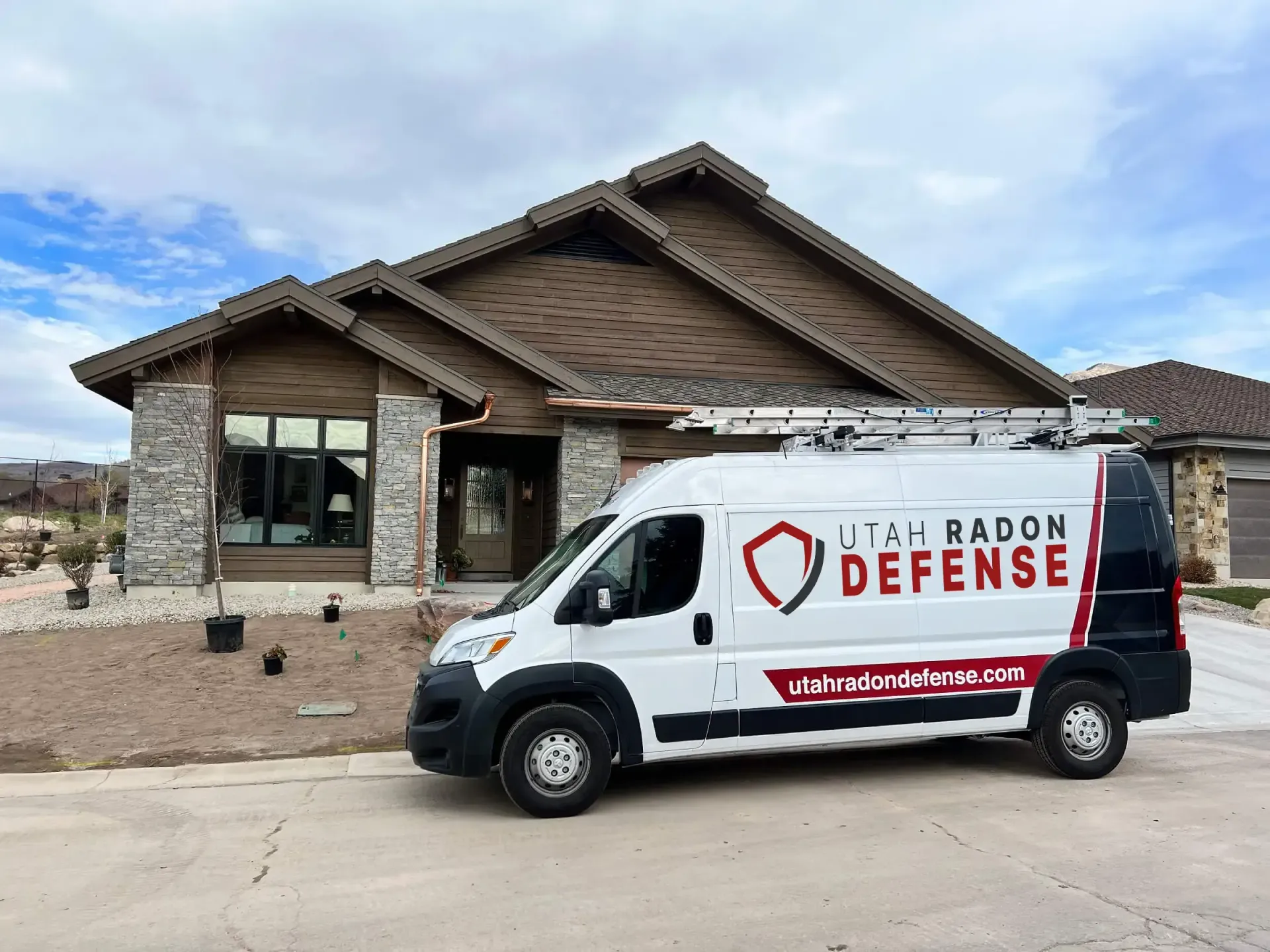 Utah Radon Defense van parked in the driveway of a Utah home at golden hour
