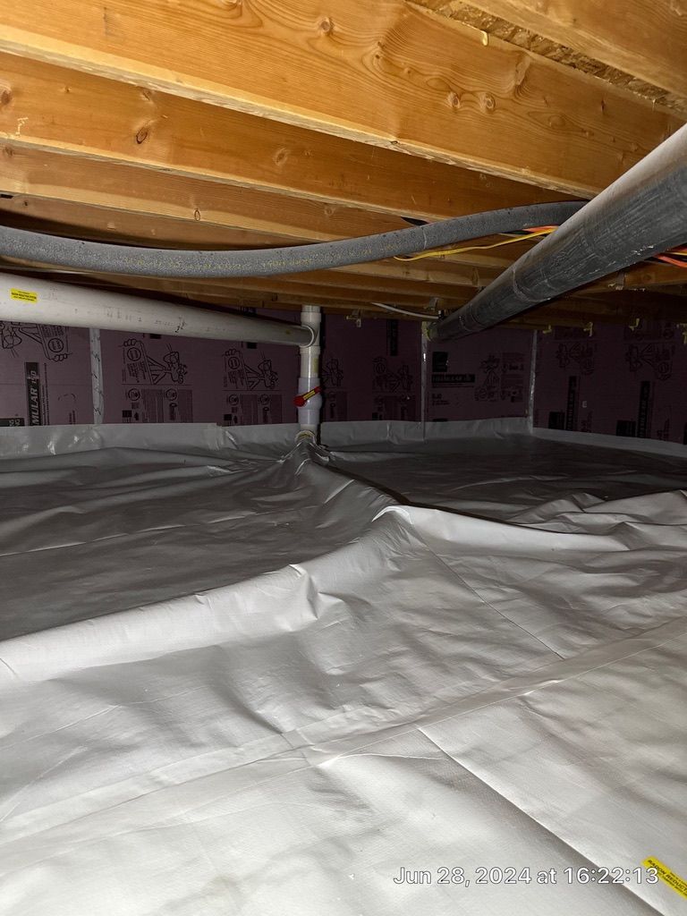 Crawlspace with plastic vapor barrier on floor, pink insulation on walls, and exposed wood joists overhead