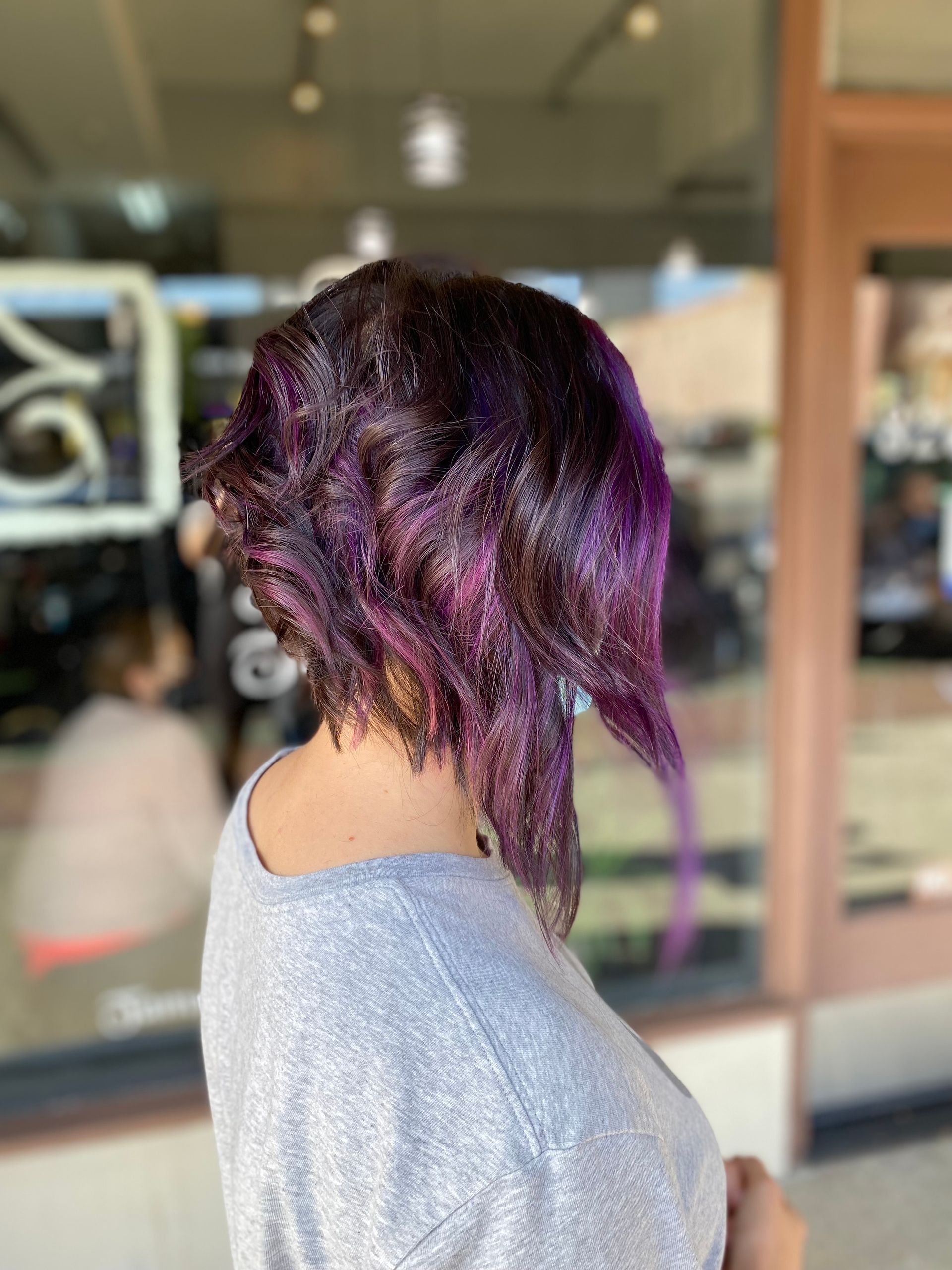 A woman is getting her hair cut by a hairdresser.