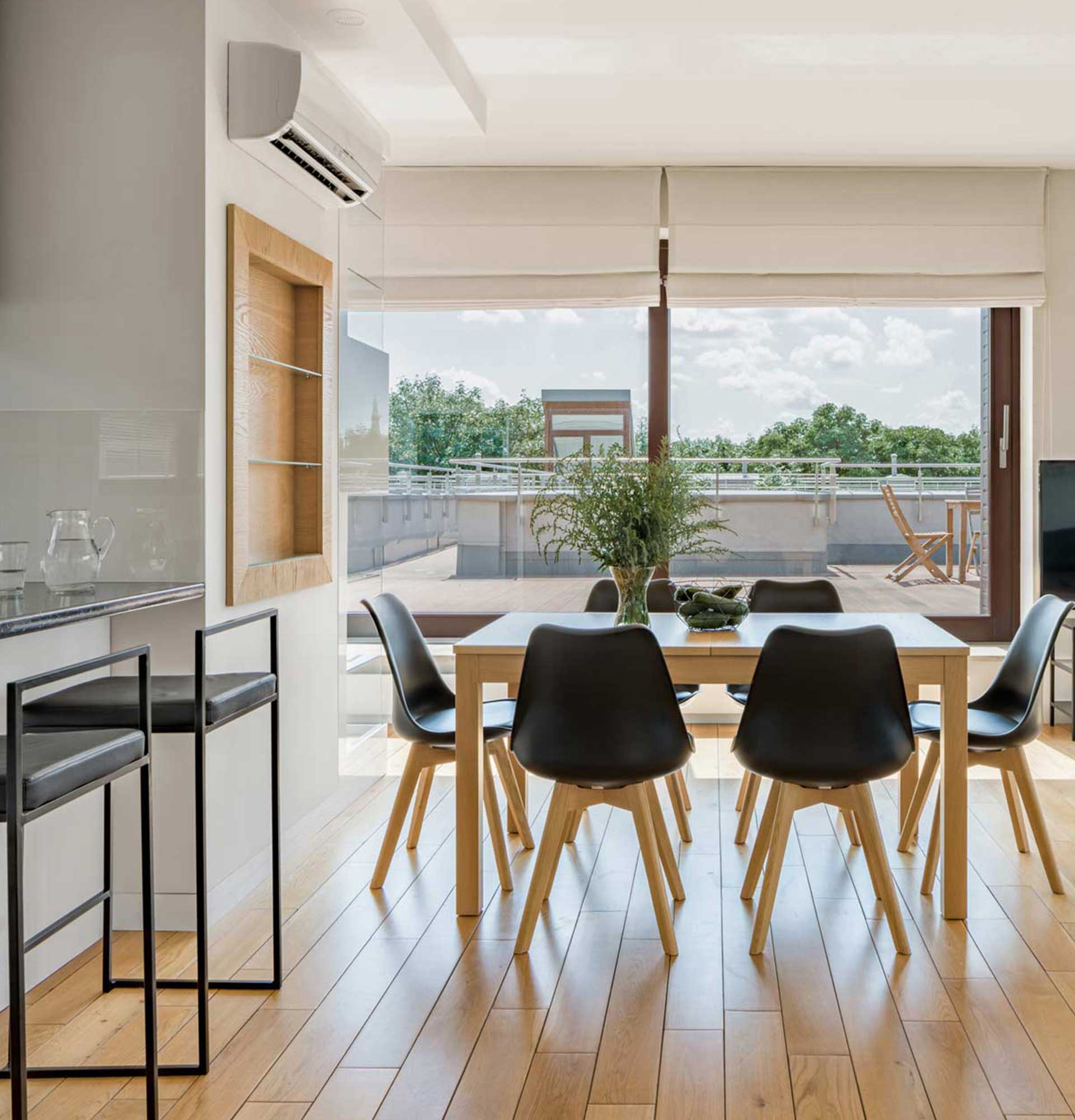 A dining room with a table and chairs and a large window
