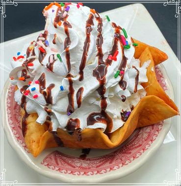Dessert: Whipped cream and sprinkles in a fried tortilla bowl, drizzled with chocolate sauce.