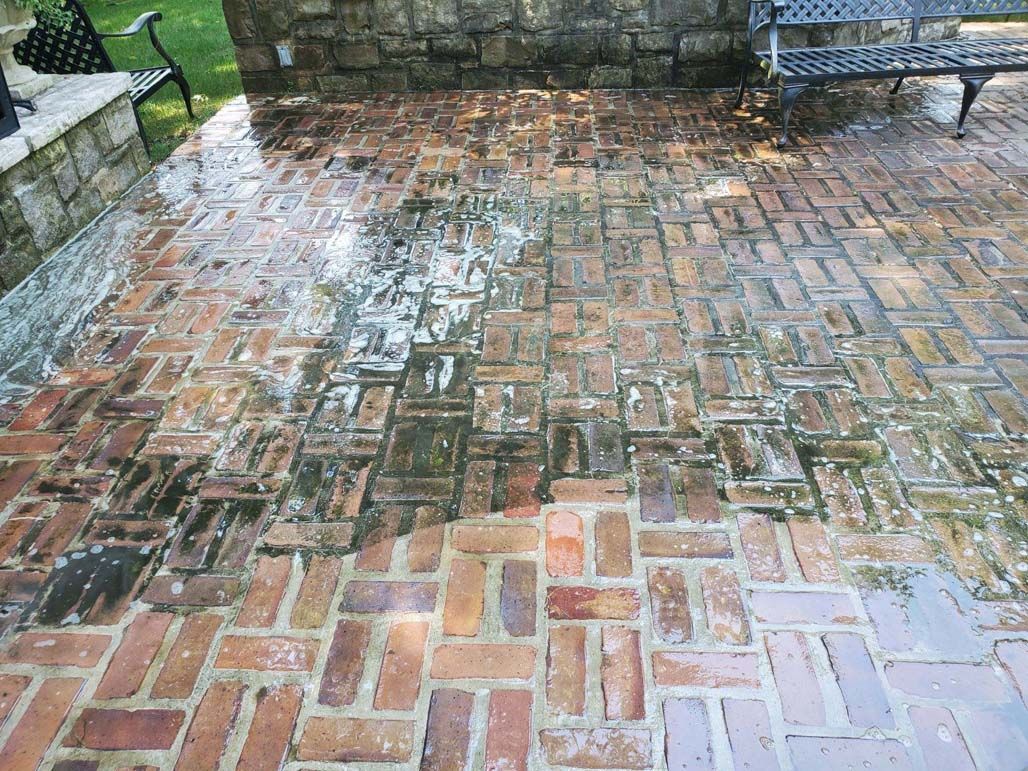 Wet brick patio with stone wall and benches after rain