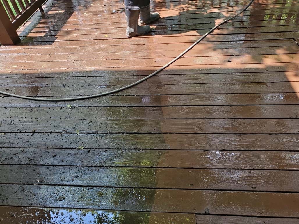 Wet wooden deck with sunlight, shadows, and a diagonal cable across the boards