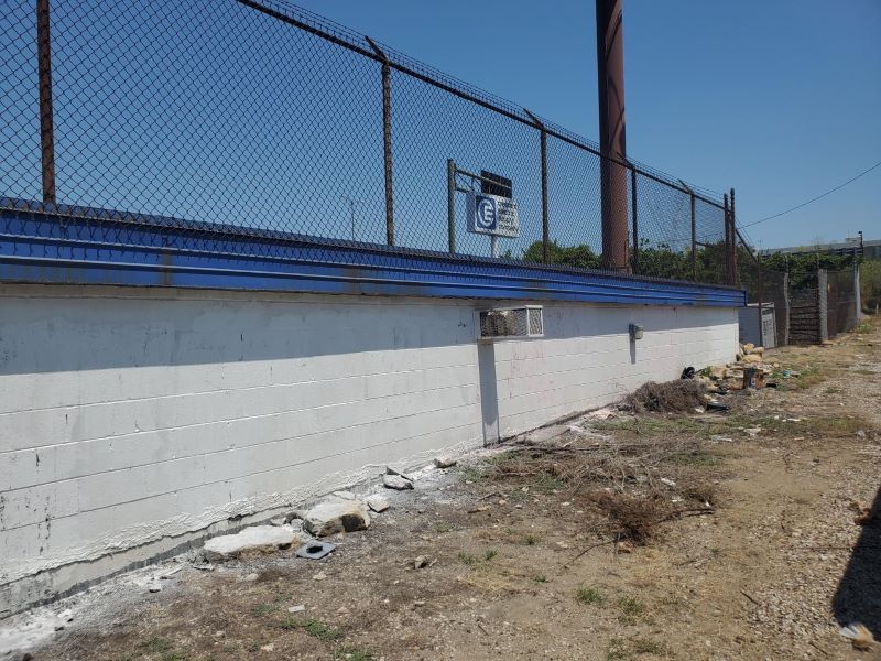 Clean white wall after graffiti was removed by chemicals and pressure washing.