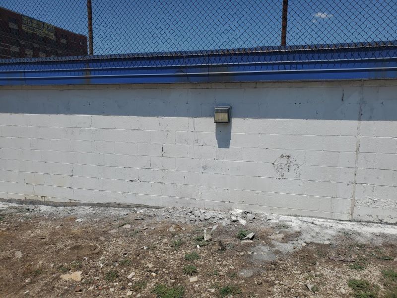 Clean white wall after graffiti was removed by chemicals and pressure washing.