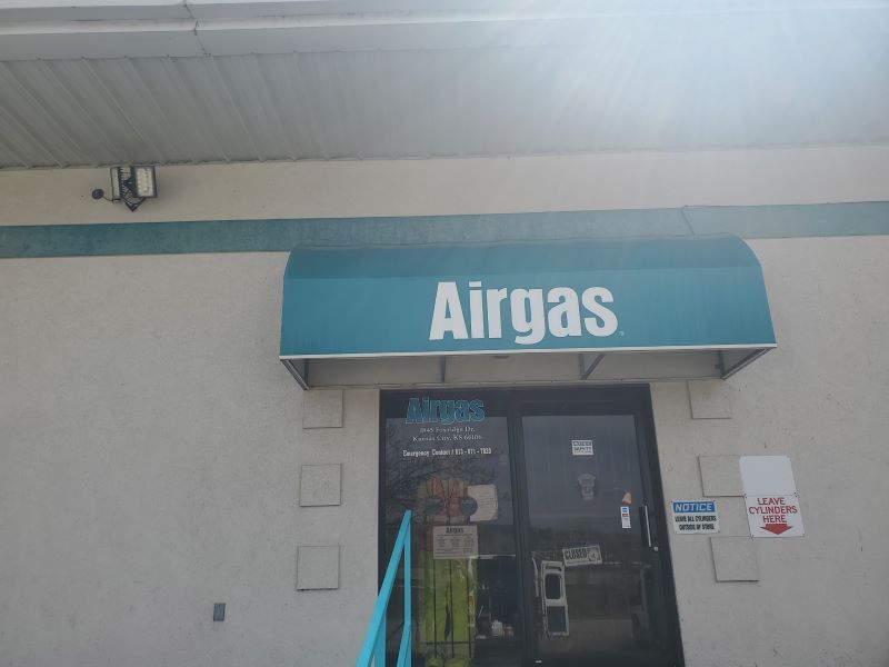 Airgas storefront with blue awning above glass entrance under a covered walkway