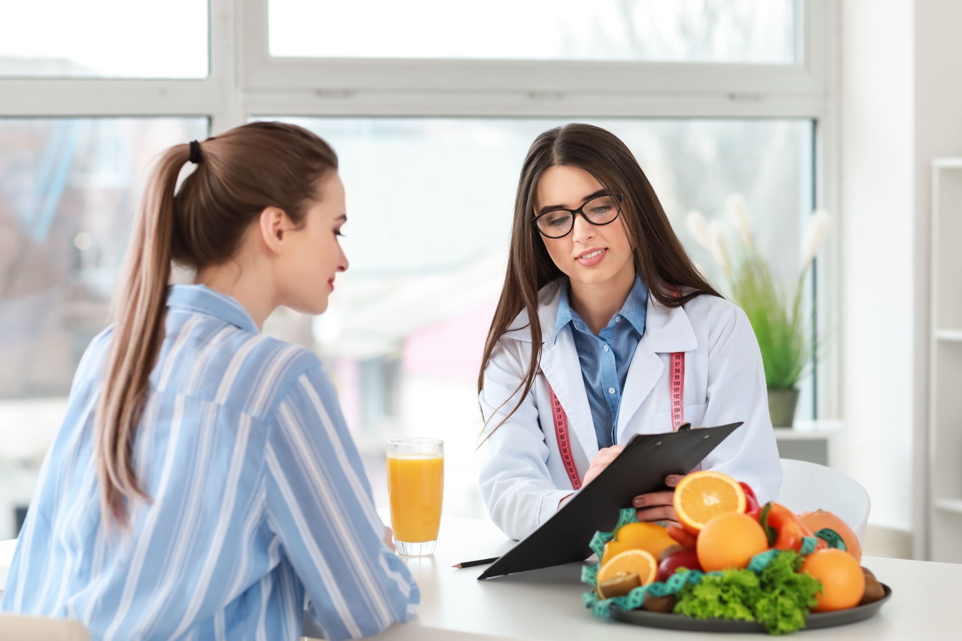 A woman is sitting at a table talking to a nutritionist.
