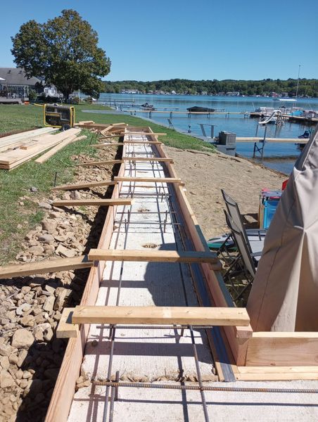 A concrete wall is being built next to a body of water.