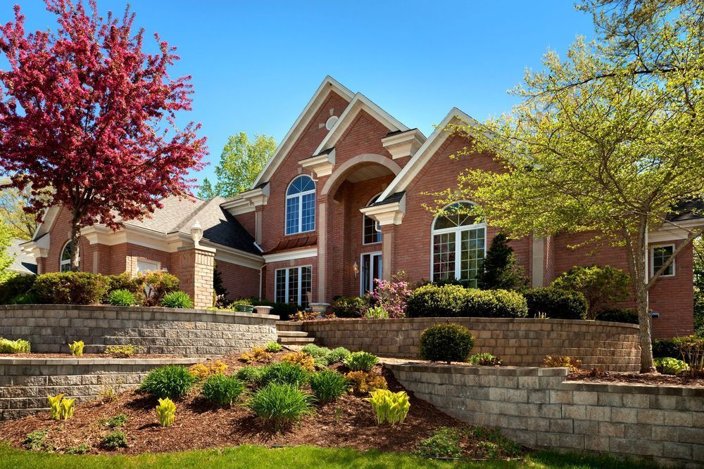 A large brick house with a tree in front of it