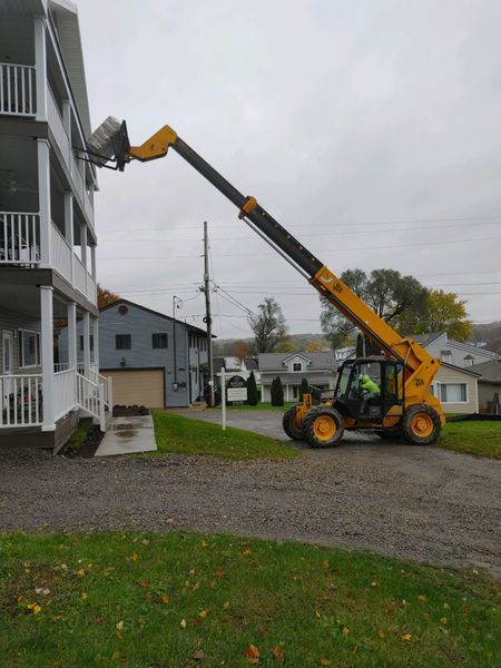 A yellow forklift is being used to lift a building