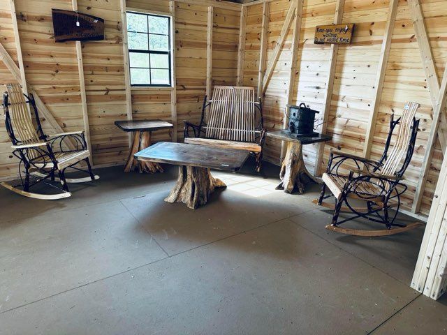 A living room with rocking chairs , a table , and a television.