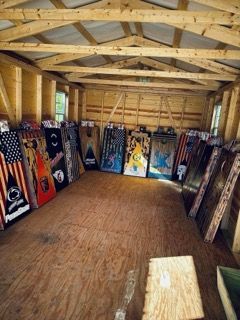 A room with a lot of cornhole boards on the floor.