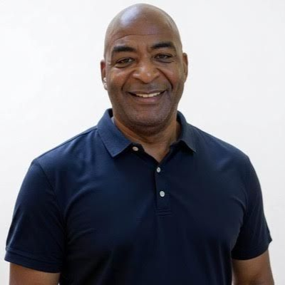Smiling man in a navy polo shirt against a plain white background