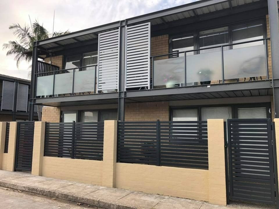 A Building with A Fence Around It and A Palm Tree in The Background — Oz-Craft in Forster, NSW