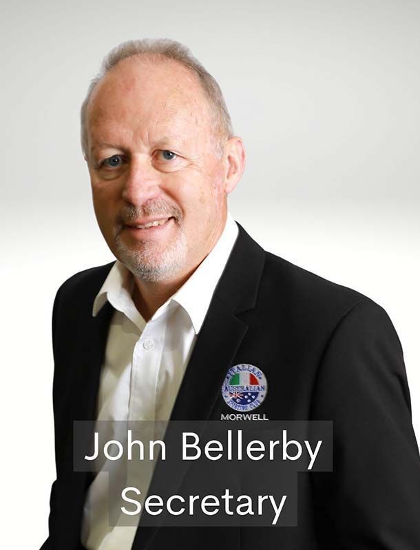Portrait of John Bellerby in a black suit, smiling with “Secretary” text overlay