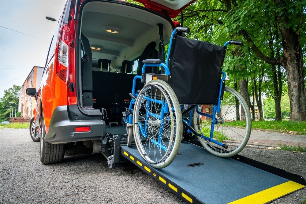 A wheelchair is being loaded into the back of a van.